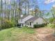 Home exterior showcasing backyard patio, lush greenery, mature trees, and ample natural light at 991 Lisa Kay Dr, Lawrenceville, GA 30046