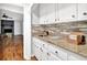 Kitchen featuring granite countertops, tile backsplash, and white cabinets at 1315 Arden Sw Dr, Marietta, GA 30008