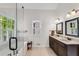 Light filled bathroom featuring a double vanity, soaking tub, and a window with shuttered blinds at 2350 Shore View Nw Way, Suwanee, GA 30024
