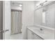 Bright bathroom features vanity with framed mirror and shower with curtain at 2350 Shore View Nw Way, Suwanee, GA 30024