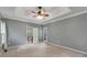 Spacious bedroom featuring a tray ceiling, neutral walls, carpet and a ceiling fan with lights at 2350 Shore View Nw Way, Suwanee, GA 30024
