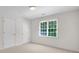 Bright bedroom featuring two doors, one window with blinds, and neutral carpet at 2350 Shore View Nw Way, Suwanee, GA 30024