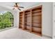 Bonus room featuring a large arched window, a ceiling fan, and custom built-in shelving units at 2350 Shore View Nw Way, Suwanee, GA 30024