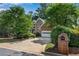 Charming brick home with an attached garage, long driveway, and mature landscaping at 2350 Shore View Nw Way, Suwanee, GA 30024