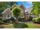 Beautiful brick home featuring a landscaped front yard, mature trees, and an attached garage at 2350 Shore View Nw Way, Suwanee, GA 30024