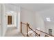 Upstairs hallway with wood banister and door leading to the exterior balcony at 2350 Shore View Nw Way, Suwanee, GA 30024