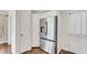 Modern stainless steel refrigerator next to white cabinets and wood floor in kitchen at 2350 Shore View Nw Way, Suwanee, GA 30024