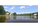 Picturesque view of the lake featuring waterfront homes nestled among lush trees on a clear and sunny day at 2350 Shore View Nw Way, Suwanee, GA 30024