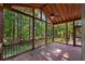 Large screened porch offering great natural light, wood beams, a ceiling fan and views of the private wooded backyard at 2350 Shore View Nw Way, Suwanee, GA 30024