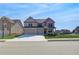 Attractive two-story brick home featuring a three-car garage, manicured lawn, and inviting curb appeal at 2447 Cadenza Cir, Dacula, GA 30019