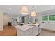 Open-concept kitchen with island, stainless steel appliances, seamlessly flowing into the dining and living spaces at 2447 Cadenza Cir, Dacula, GA 30019
