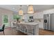 Bright kitchen features white cabinets, stainless appliances, pendant lighting, and a large island with bar seating at 2447 Cadenza Cir, Dacula, GA 30019