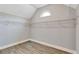 Walk-in closet with adjustable shelving and wood-style laminate flooring at 2994 Ash Grove Sw Dr, Conyers, GA 30094