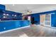 Modern living room featuring stylish blue walls, gray laminate flooring and a sliding barn door at 2994 Ash Grove Sw Dr, Conyers, GA 30094