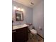 Cozy powder room offers wood vanity with granite top and updated lighting at 406 Vivian Way, Woodstock, GA 30188