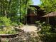 Landscaped pathway leading to a brown two-story home surrounded by lush trees at 406 Vivian Way, Woodstock, GA 30188