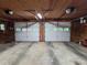 Spacious garage with two overhead doors each having windows and overhead storage, work space and lighting at 406 Vivian Way, Woodstock, GA 30188