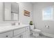 Elegant bathroom features a white vanity with a marble countertop, toilet, and window for natural light at 7095 Evening Dew Dr, Cumming, GA 30028