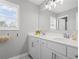 Bright bathroom with double vanity, white cabinets, a large mirror, and a window letting in natural light at 7095 Evening Dew Dr, Cumming, GA 30028