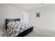 A simply decorated bedroom featuring a bed with a blue and white leaf print, and light gray carpeting at 7095 Evening Dew Dr, Cumming, GA 30028