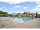 Large community pool with adjacent clubhouse and plenty of seating for residents at 7095 Evening Dew Dr, Cumming, GA 30028