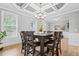Elegant dining area featuring wainscoting, a tray ceiling and natural light from large windows at 7095 Evening Dew Dr, Cumming, GA 30028