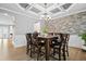 Dining room with a large wooden table, seating for six, and decorative stone accent wall at 7095 Evening Dew Dr, Cumming, GA 30028