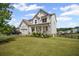 Beautiful two-story home featuring a spacious front yard, a front porch and attached two car garage at 7095 Evening Dew Dr, Cumming, GA 30028
