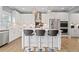 Modern kitchen featuring white cabinets, stainless steel appliances, and an island with seating for three at 7095 Evening Dew Dr, Cumming, GA 30028