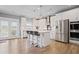 Bright kitchen with white cabinets, stainless appliances, large island, and a door leading to the backyard at 7095 Evening Dew Dr, Cumming, GA 30028