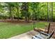 A lush green backyard featuring mature trees and a defined border at 1065 Dalby Way, Austell, GA 30106