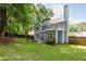 Well-maintained backyard with a light blue house, green grass, and mature trees at 1065 Dalby Way, Austell, GA 30106