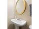 Elegant pedestal sink in the bathroom with a gold-framed mirror and a neutral color scheme at 1065 Dalby Way, Austell, GA 30106