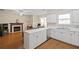 Spacious kitchen with white cabinets, a breakfast bar, and an adjacent fireplace living area at 1065 Dalby Way, Austell, GA 30106