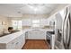 Open kitchen with stainless steel appliances, white cabinets, and an adjacent living area at 1065 Dalby Way, Austell, GA 30106