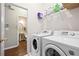 Well-equipped laundry room with modern washer and dryer units, shelving, and access to the bathroom at 1065 Dalby Way, Austell, GA 30106