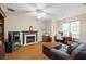 Comfortable living room featuring a fireplace, ceiling fan, and wood-look floors, creating a cozy atmosphere at 1065 Dalby Way, Austell, GA 30106
