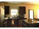Modern kitchen with dark cabinets, granite countertops, and stainless steel appliances, perfect for cooking at 1231 St James Pl, Loganville, GA 30052