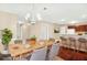 Bright dining room features stylish chandelier, wood table set for six, and bar seating for casual dining at 132 Tara Commons Dr, Loganville, GA 30052