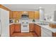 Bright kitchen with white appliances, wooden cabinets, and white countertops at 132 Tara Commons Dr, Loganville, GA 30052