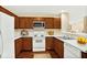 Efficient kitchen featuring white appliances, warm wood cabinetry, and ample counter space at 132 Tara Commons Dr, Loganville, GA 30052