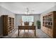 Home office featuring built-in bookcases, desk, ceiling fan and natural light at 132 Tara Commons Dr, Loganville, GA 30052