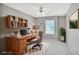Bright home office featuring a wooden desk, built-in shelves, and a comfortable chair at 132 Tara Commons Dr, Loganville, GA 30052