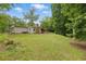 Beautiful backyard featuring plenty of lush green grass, mature trees, and a screened porch at 1447 High Sierra Dr, Lawrenceville, GA 30043