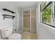 Bathroom featuring a glass enclosed shower, decorative shelves, and a window to the outdoors at 1447 High Sierra Dr, Lawrenceville, GA 30043