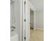Bathroom features a shower-tub combo and storage shelving on the opposite wall at 1447 High Sierra Dr, Lawrenceville, GA 30043