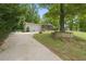Charming single-story home with a long driveway and a screened in front porch surrounded by lush greenery at 1447 High Sierra Dr, Lawrenceville, GA 30043