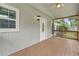 Inviting screened-in front porch with a white front door and wood flooring providing a relaxing outdoor space at 1447 High Sierra Dr, Lawrenceville, GA 30043
