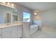 Bright bathroom featuring a standalone tub, white marble tile and a large vanity at 2436 Cadenza Cir, Dacula, GA 30019