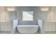 Bright bathroom featuring a standalone tub, white marble tile, and dual vanities at 2436 Cadenza Cir, Dacula, GA 30019